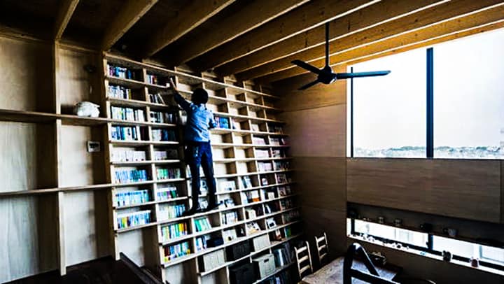 De hellende boekenplank van vloer tot plafond